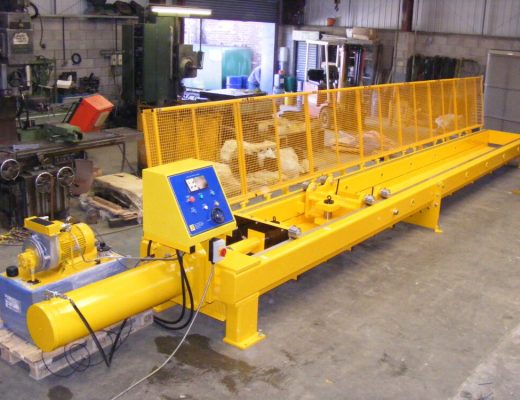a yellow horizontal tensile test machine with yellow mesh guards open