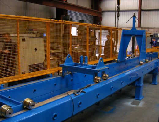 Tensile Test Machine with Guards open and special adaptors to hold the sample over an obstacle, enabling testing of the sample when a bend is applied.