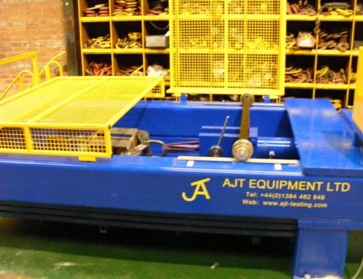 Blue horizontal test machine with yellow guards - AJT Equipment is stencilled on the blue machine
